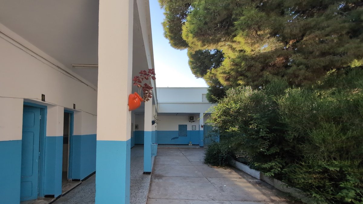 A blue and white colonnade beside the school gardens